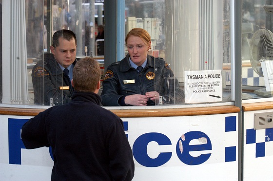 A member of the public talking to two police officers in the police information booth