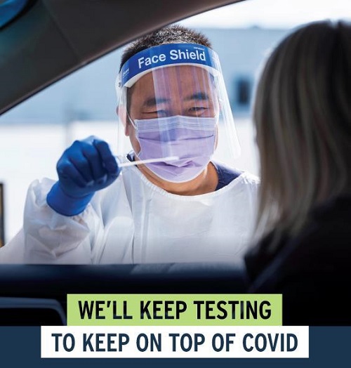 A medical professional of Asian background about to conduct a COVID-19 test. The man is wearing a mask.